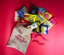 Stor julsäck i juteväv med rött band och utvalda varumärkesfavoriter