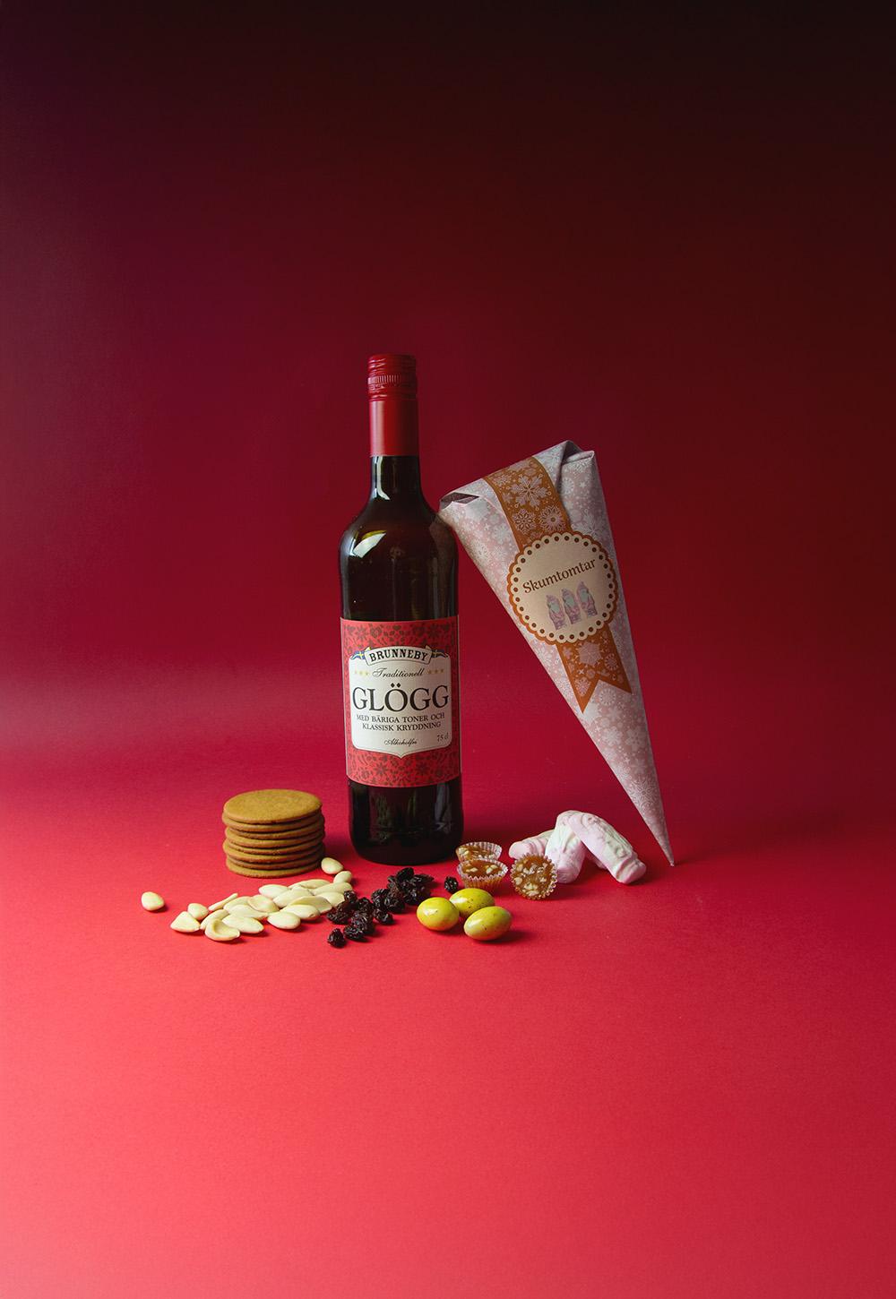 Glöggkit i julig miljö med klassiska tillbehör Glögg med pepparkakor, mandlar, russin och skumtomtar i julig miljö